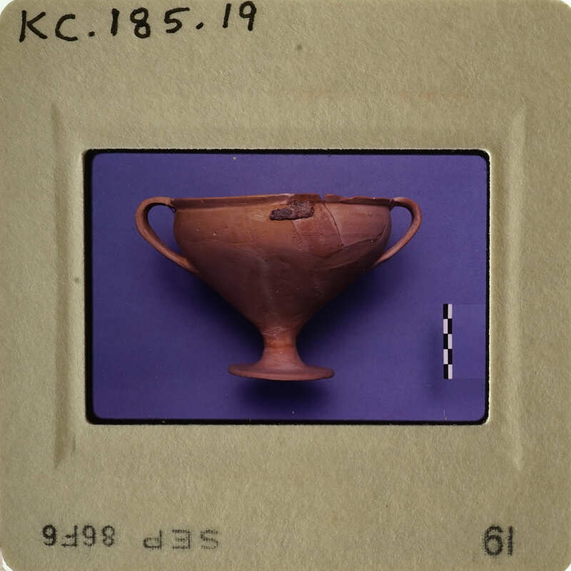 Ancient Greek vase with handle and foot on blue background.