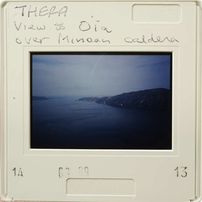 Aerial view of a coastline with mountains and water, captured on an old photographic film strip.