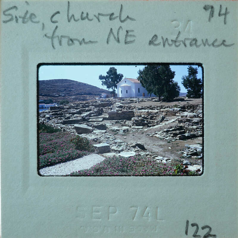 White church in center surrounded by stone wall remains