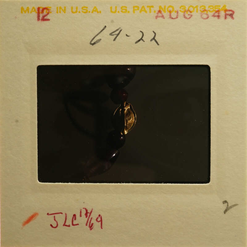 A photograph of an antique necklace with a gold clasp.