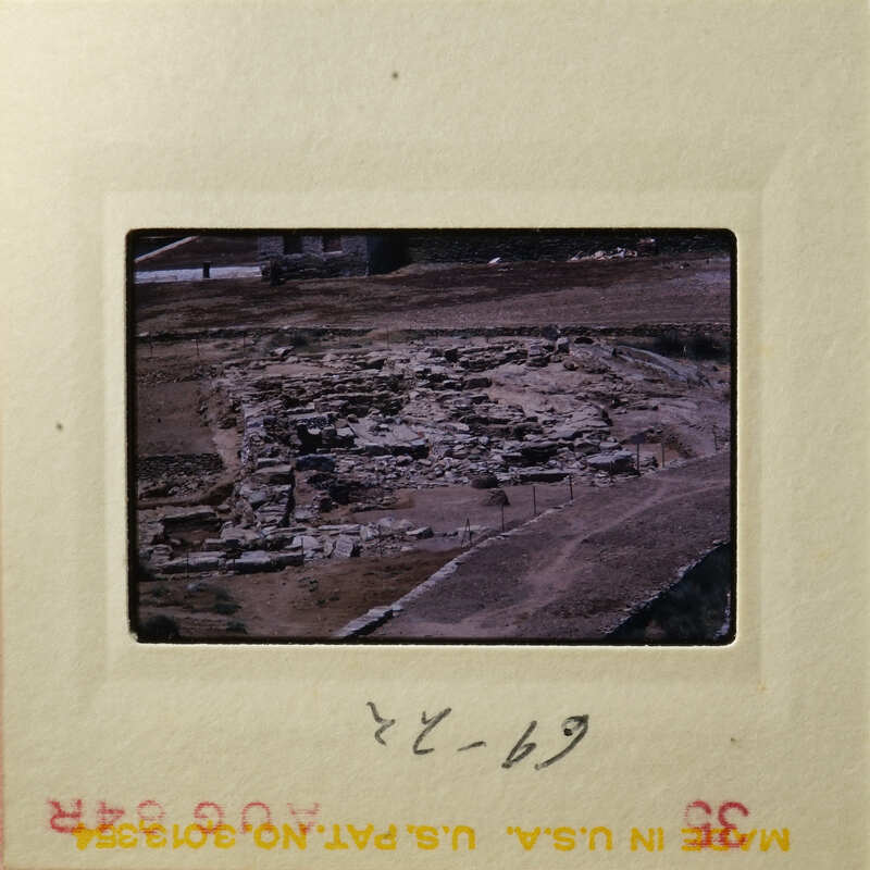 Aerial view of an ancient archaeological site with stone ruins and dirt paths.