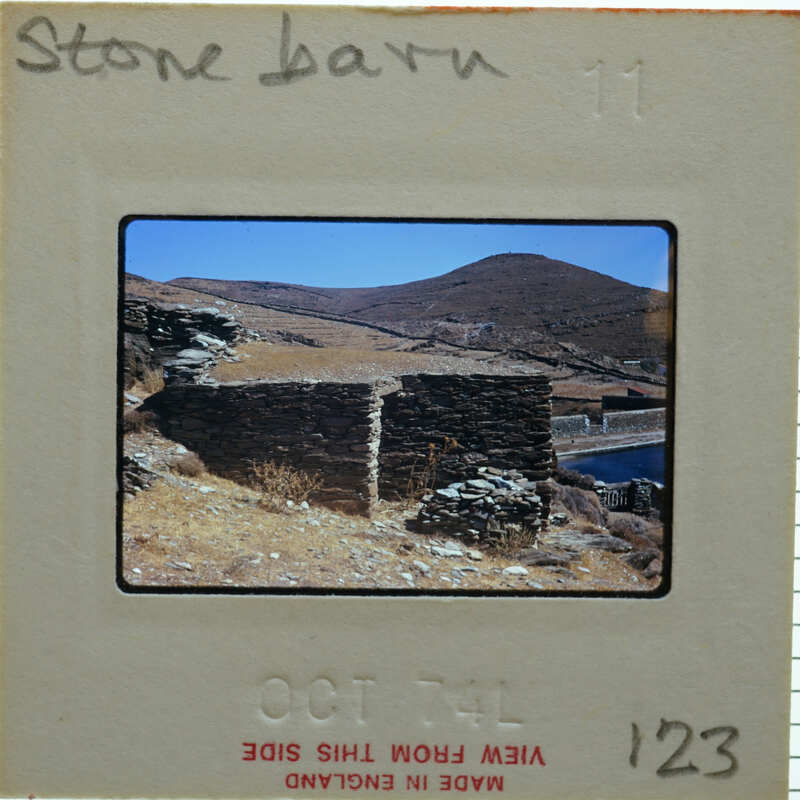 A slide of a stone structure with mountains in the background.