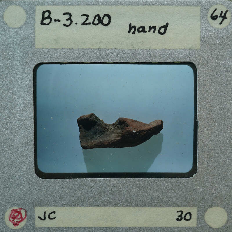 A photograph of a rock with handwritten notes on the border, possibly indicating its type or classification.