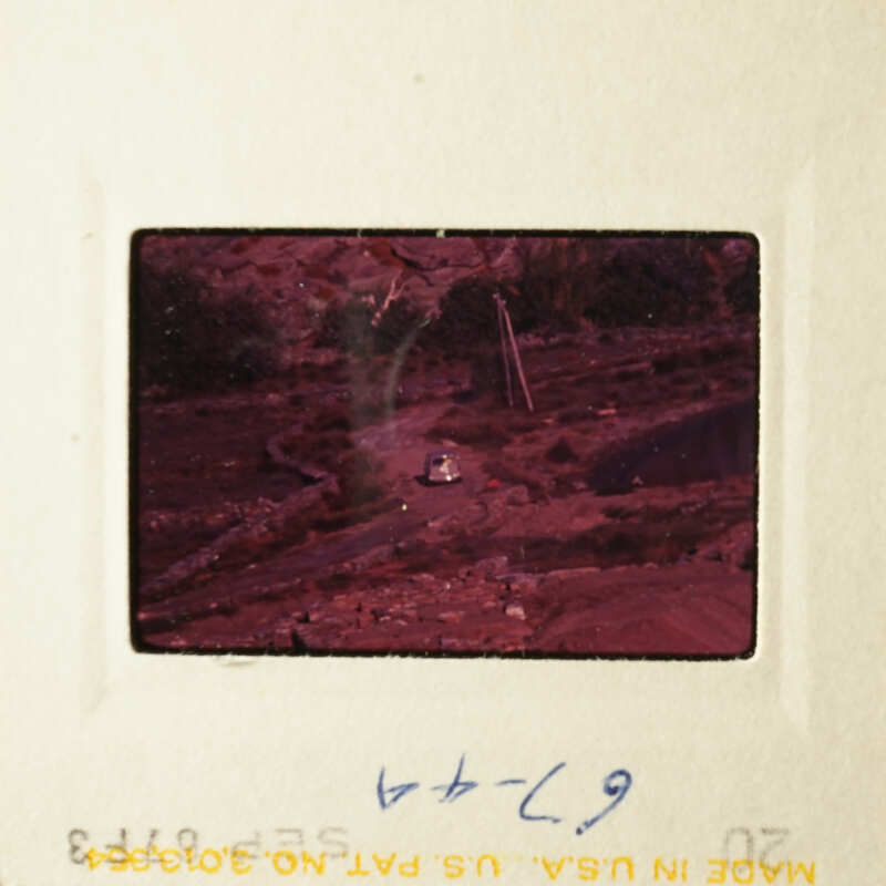 "A vintage photograph depicting a tranquil rural scene with a dirt road and a solitary figure."