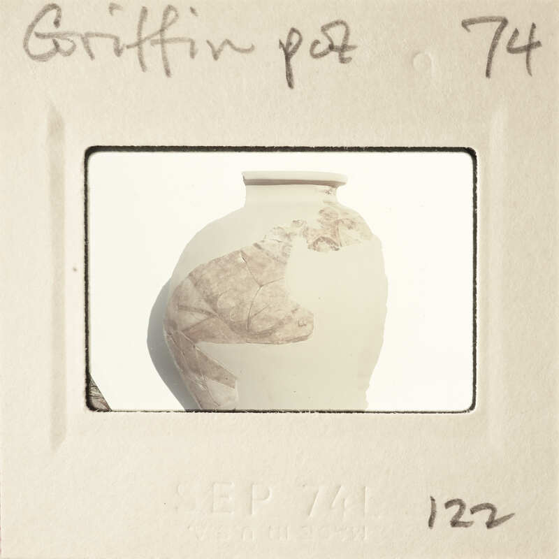 This is an image of a clay pot with a label and number on it, suggesting it's part of a collection or inventory.