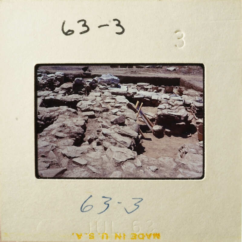 This is an image of an archaeological site with stone ruins and excavation equipment.