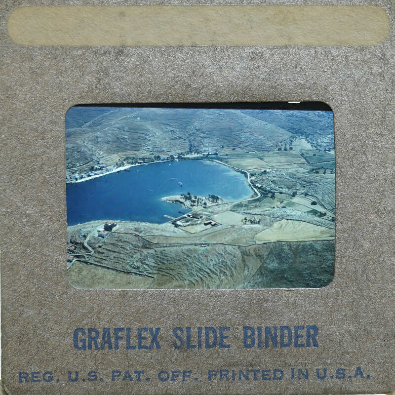 An old photograph of a lake and mountains.