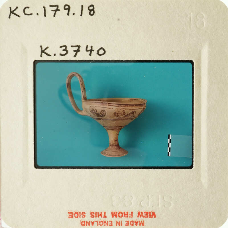 Ancient Greek-style vase with handle and neck, photographed on blue background.