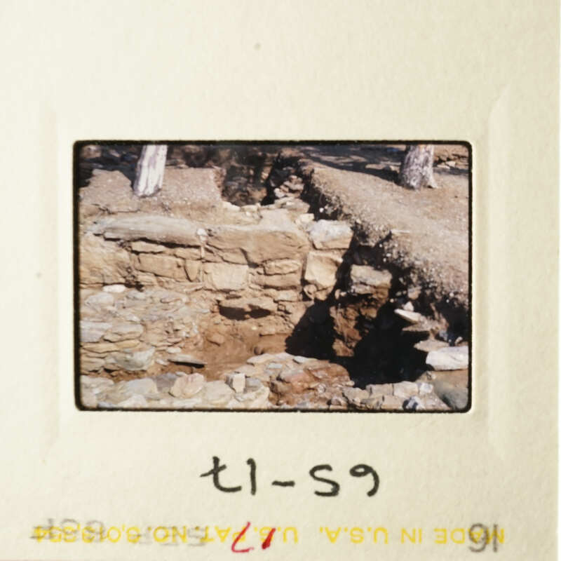 A photograph of an old stone wall with a dirt path leading up to it.