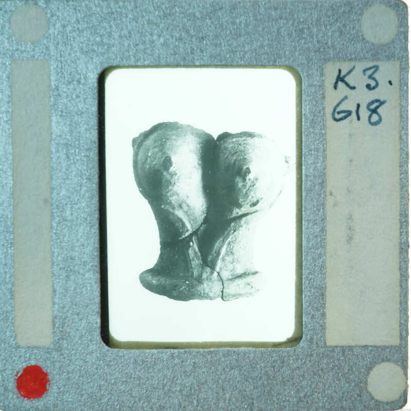 Terracotta figurine torso from front.