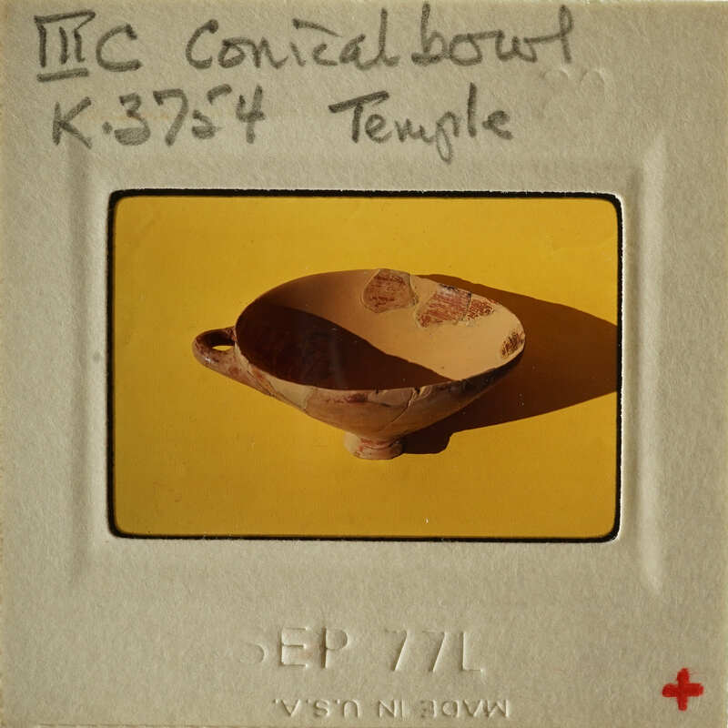 Ancient ceramic bowl with worn edges and visible cracks, displayed against yellow background.