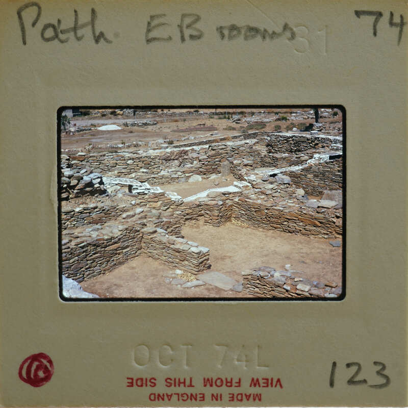 A photograph of an archaeological site with stone ruins and a dirt ground, taken on October 7, 1974.