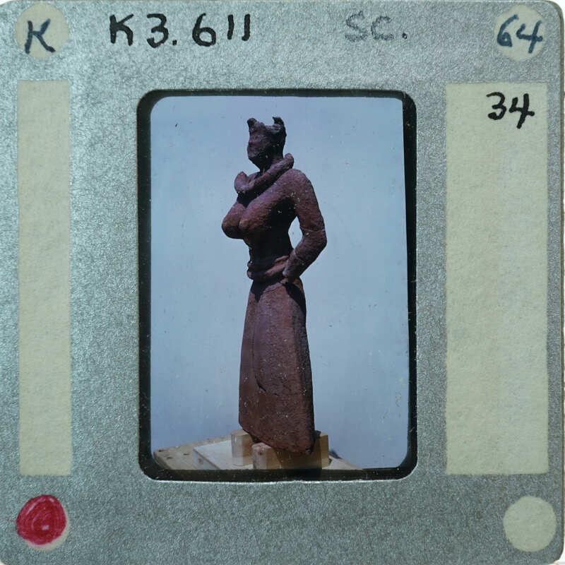 Detail of almost complete terracotta figurine from the side minus right arm.