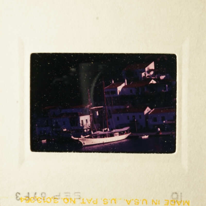 A black and white photo of a harbor town with boats.