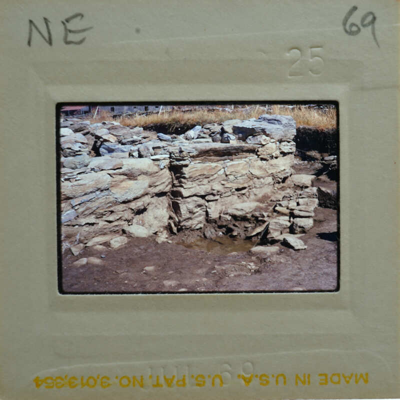 Old stone ruins with a muddy ground, captured on film.