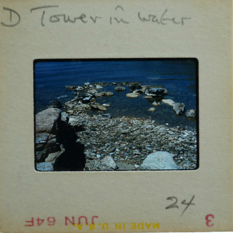 A vintage photograph of a rocky shoreline with water and a tower, labeled "Tower in Water".