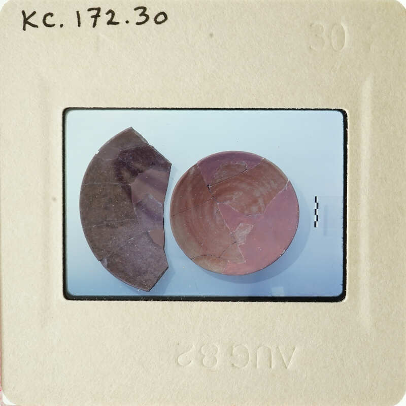 Two broken pottery shards on a white surface.