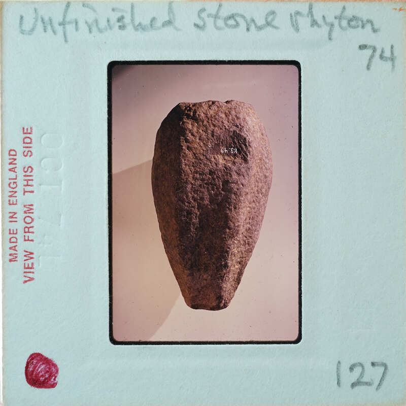 Cylindrical stone tapering towards the bottom, from the side.