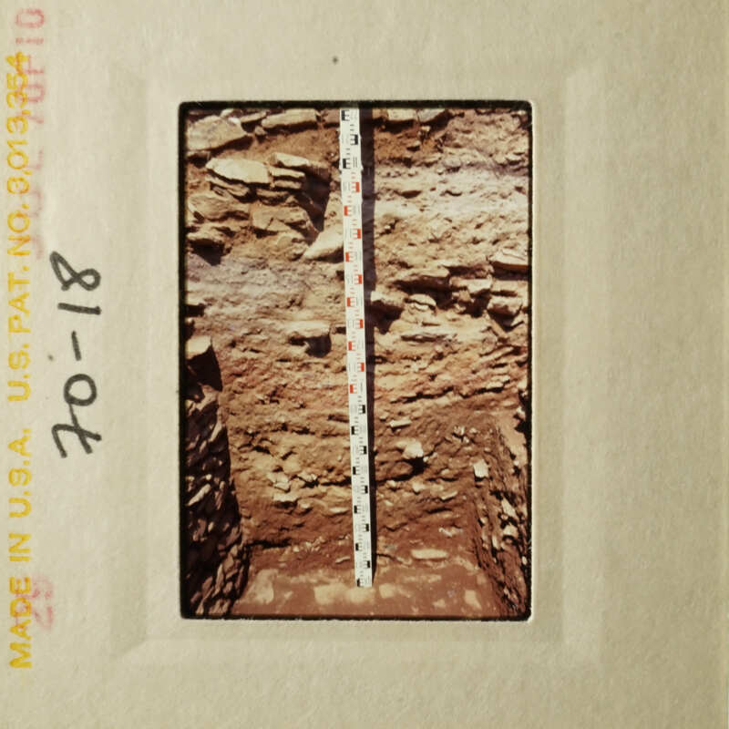 A ruler measuring the depth of an excavation site.