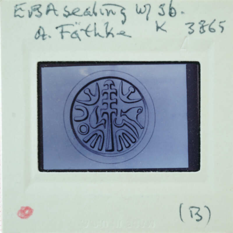A circular metal object with intricate designs, possibly a seal or emblem