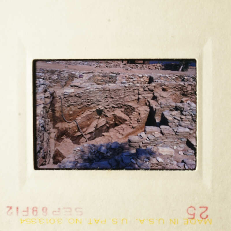 The image shows a large, ancient stone structure with multiple layers and openings, possibly an archaeological site.