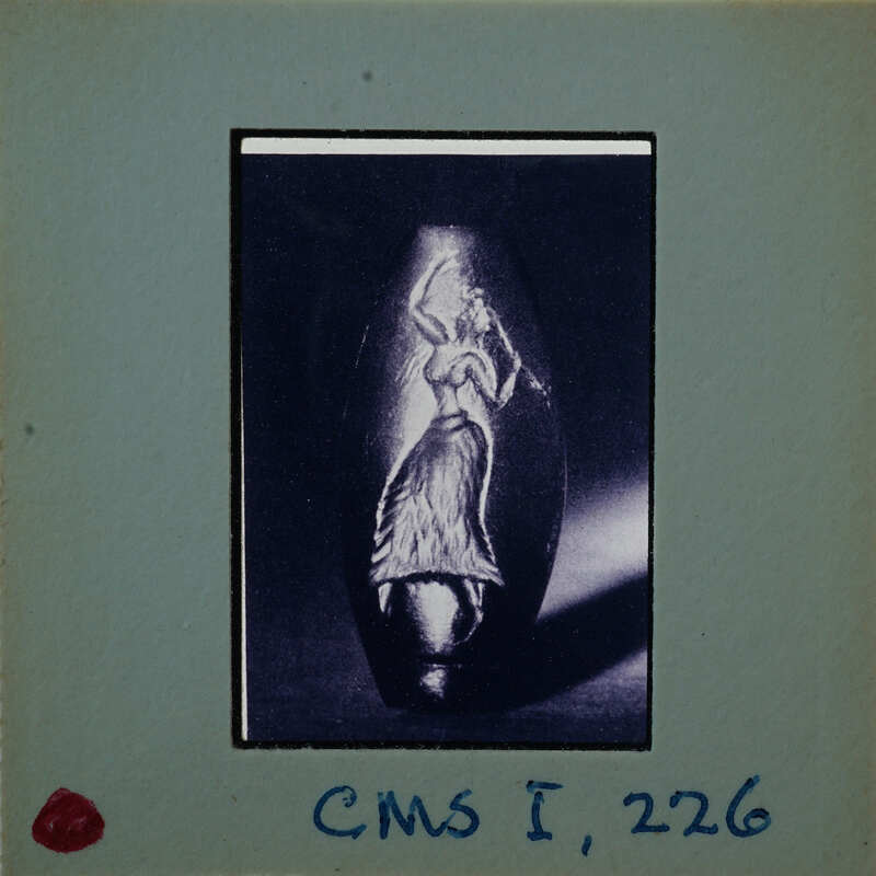 A photograph of an ancient seal stone with a depiction of a human figure.