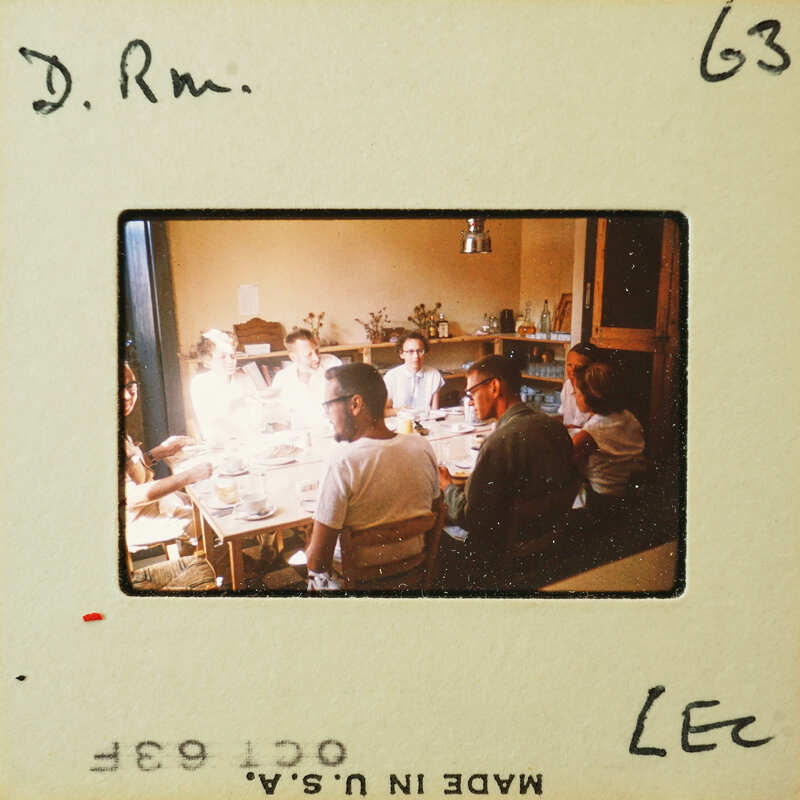 A group of people sitting around a table, likely engaged in conversation or mealtime.