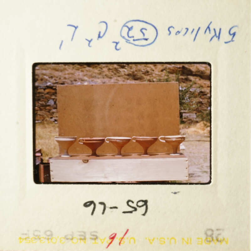 The image shows three brown bowls on a table, with a cardboard box behind them.