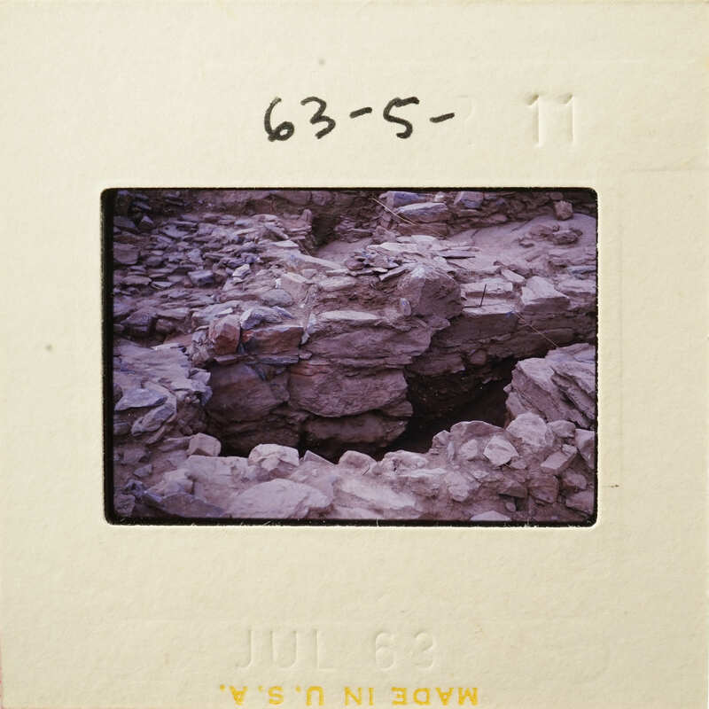 Old photograph on film strip depicting rock formations and ruins.