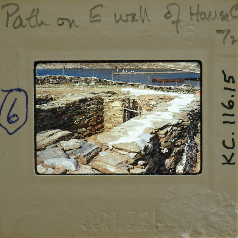 Old photograph of a stone wall with a path leading to it, possibly from an archaeological site.