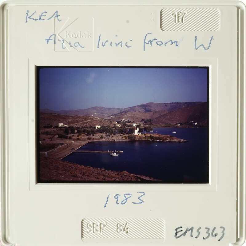 A photograph of a coastal village with boats and mountains in the background, dated September 1983.