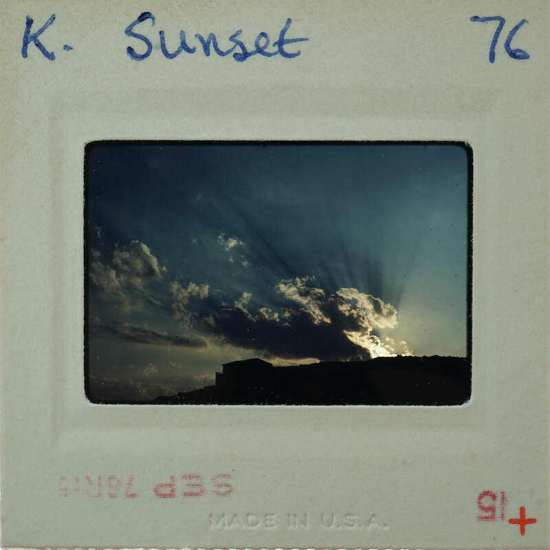 A vintage sunset photo with a white border and handwritten notes on the back.