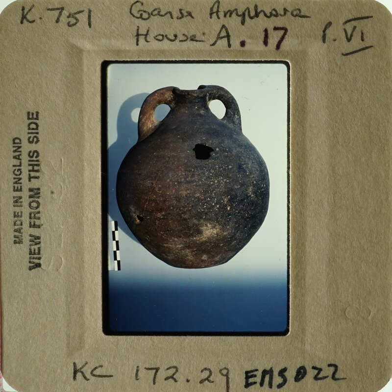 Ancient pottery displayed on a white background with a label.