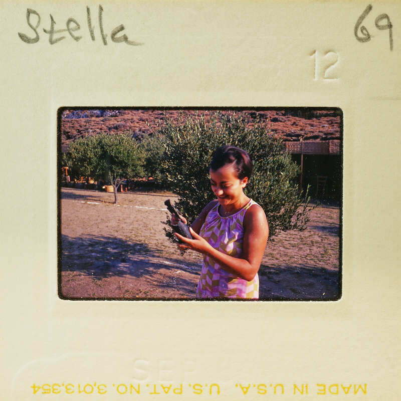 Woman holding a bird in her hand, smiling at the camera.