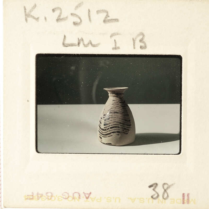 A small, dark-colored ceramic vase with a pattern on display.