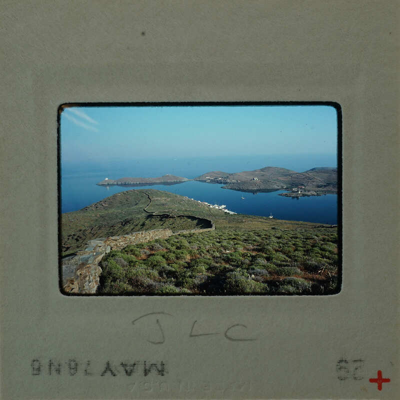 Slide of a scenic landscape with water, mountains, and a clear sky.