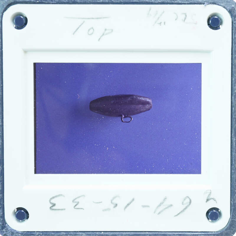 Round metal object with loop handle.