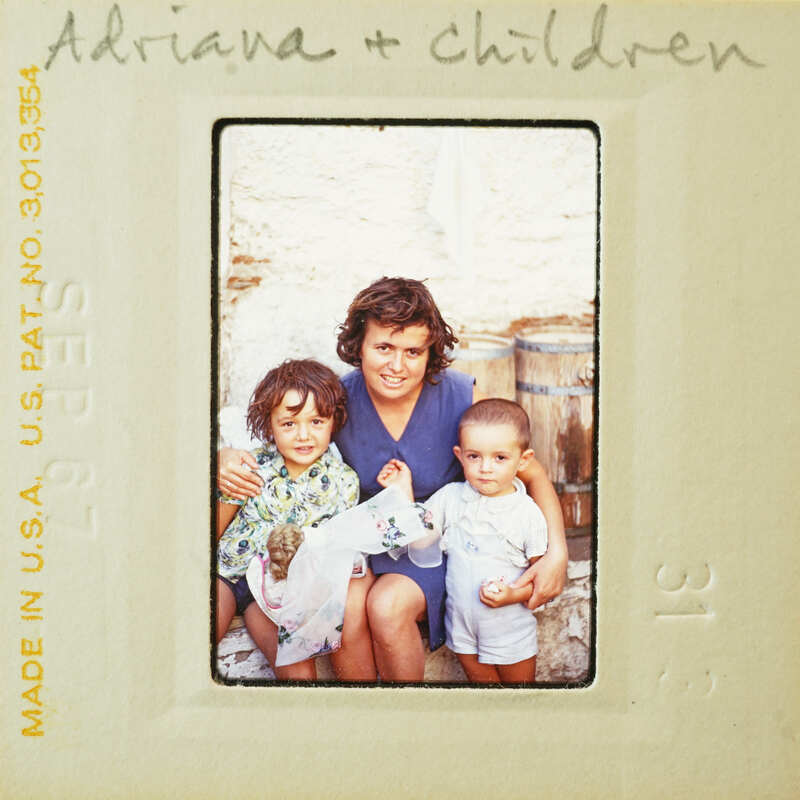 A woman and three children posing together, with a vintage or aged appearance to the image.
