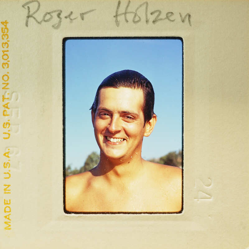 Man smiling at camera with no shirt on.