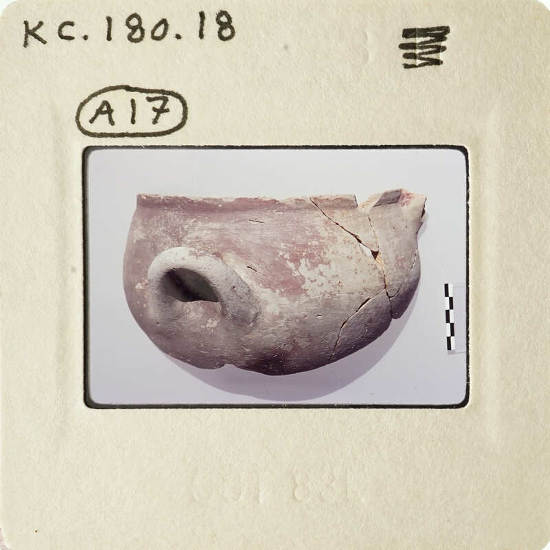 A photograph of an ancient clay pot with visible cracks and imperfections.