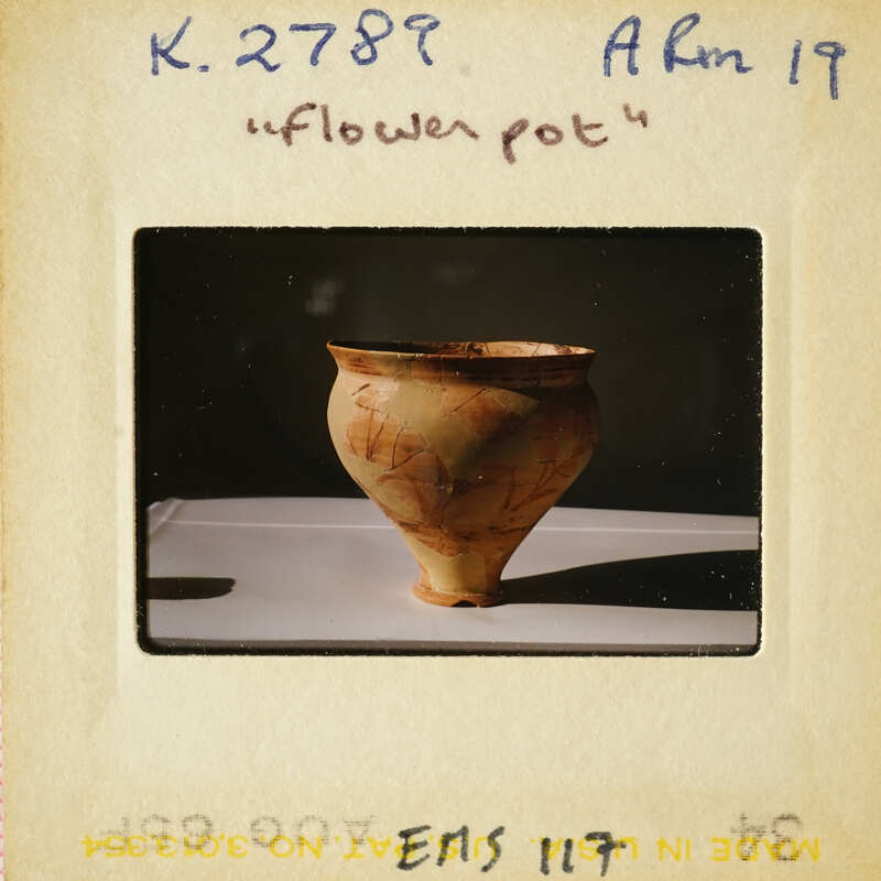 Ancient pottery on display with visible cracks and wear, photographed against a neutral background.