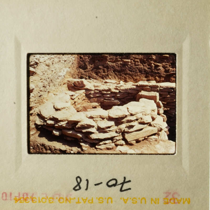 A photograph depicting an ancient stone structure, possibly a wall or ruins, with a yellowed appearance indicative of age.