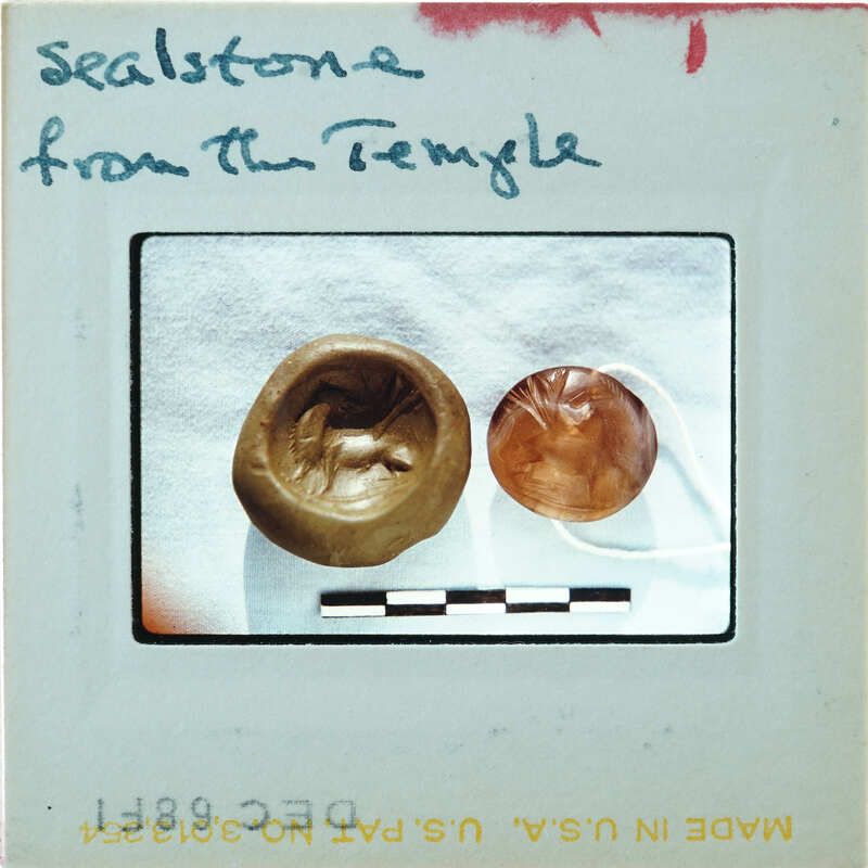 Circular stone object on right with carvings K6.288, seal impression on left.