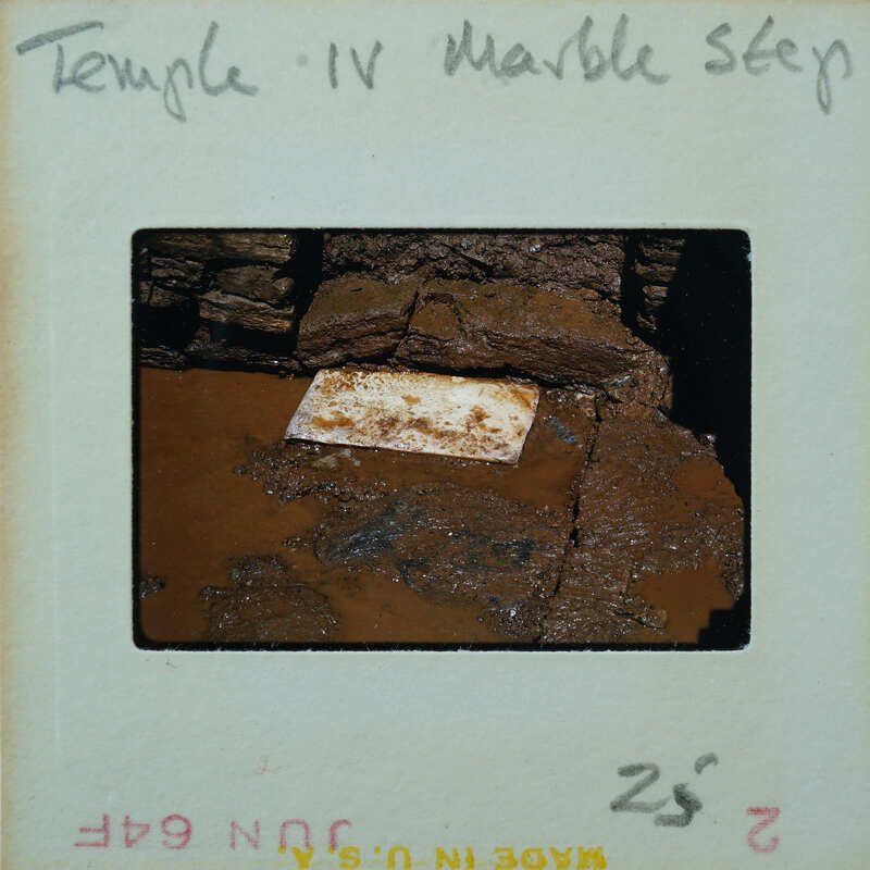 Marble step in muddy floor of building interior.