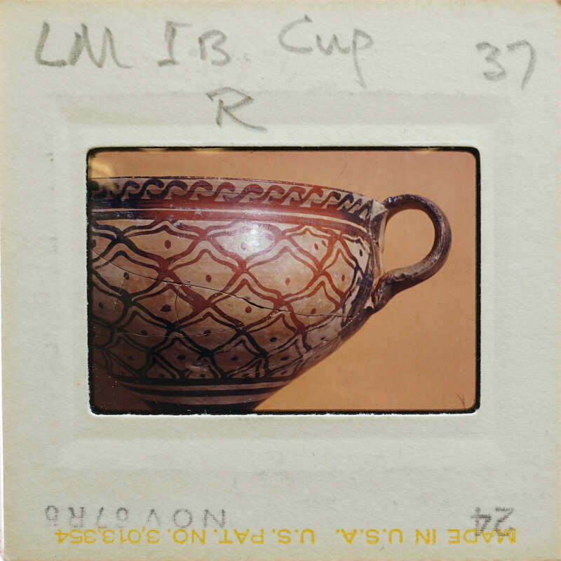 Detail of cup with intricate designs and handle.
