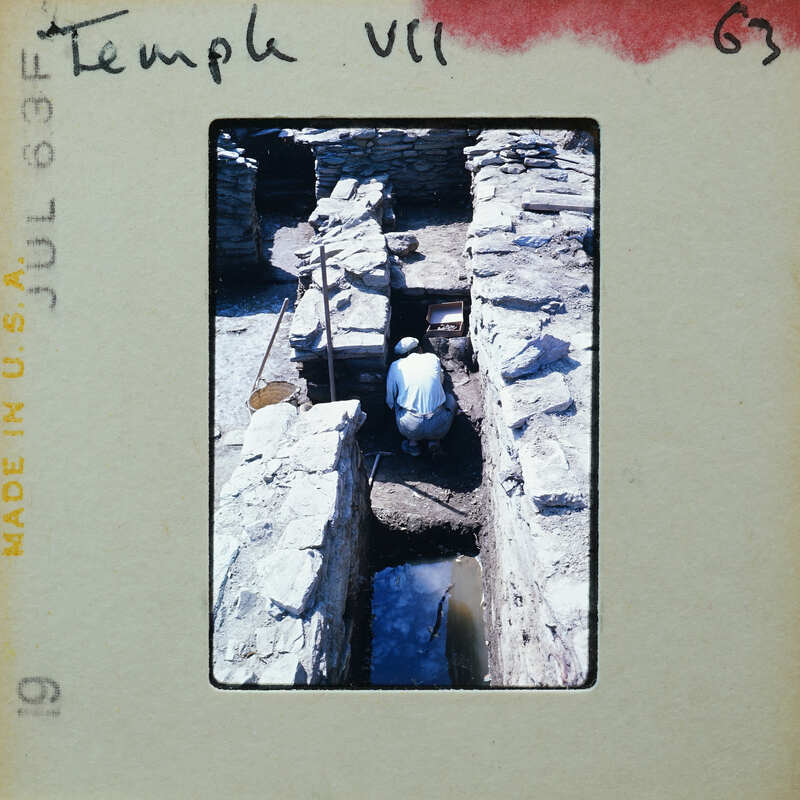 A person working on the ruins of an ancient stone structure.