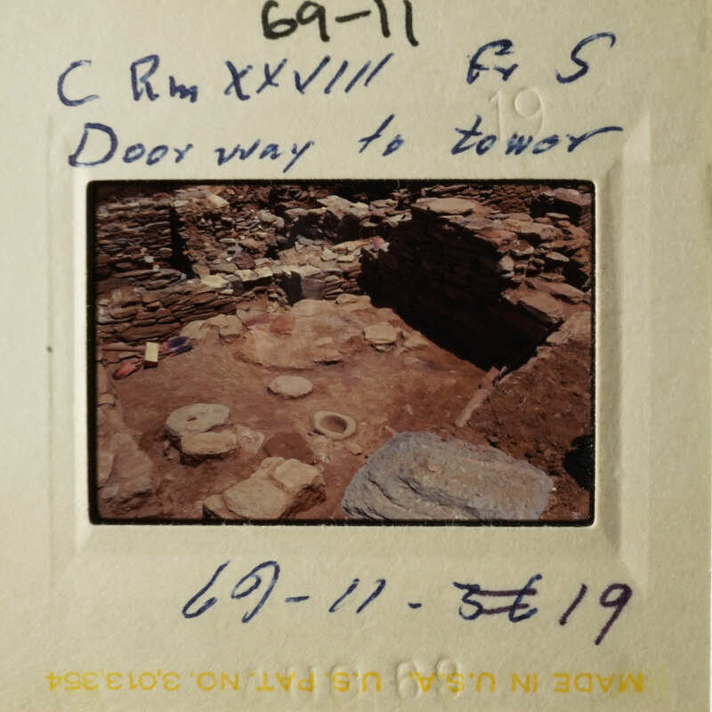 The photo shows an old slide with writing on it, depicting an archaeological site with ruins and a handwritten note.