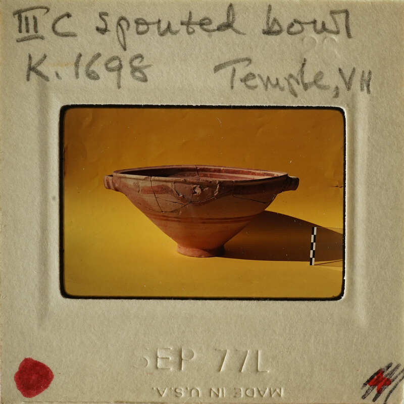 Ancient clay bowl with markings on display.