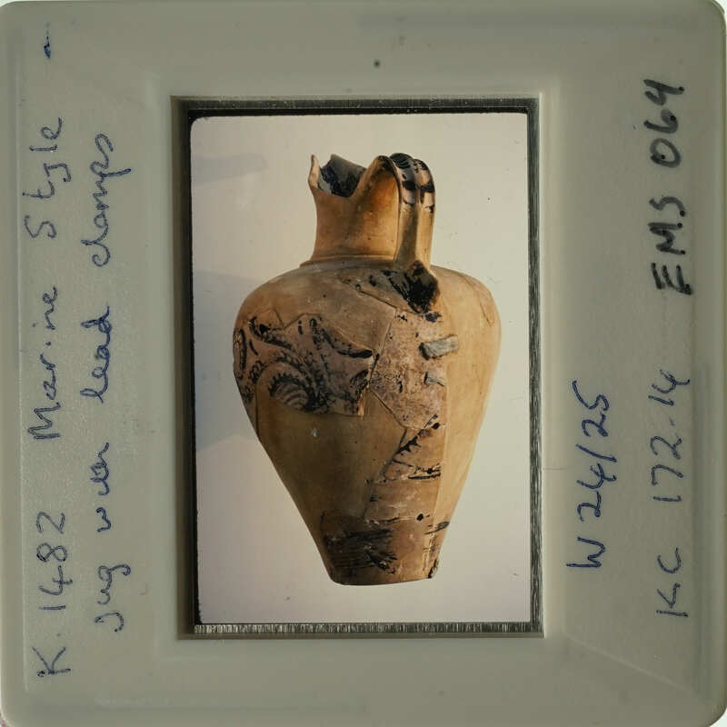 Ancient vase with intricate designs displayed on a white surface.