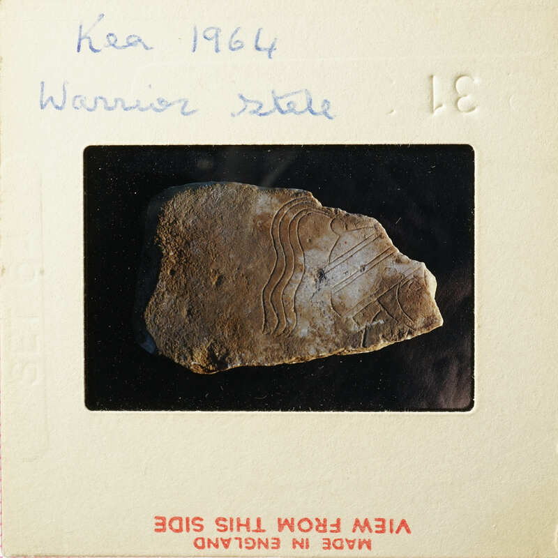 A photograph of an ancient artifact with markings, possibly a piece of pottery or stone, set against a dark background.